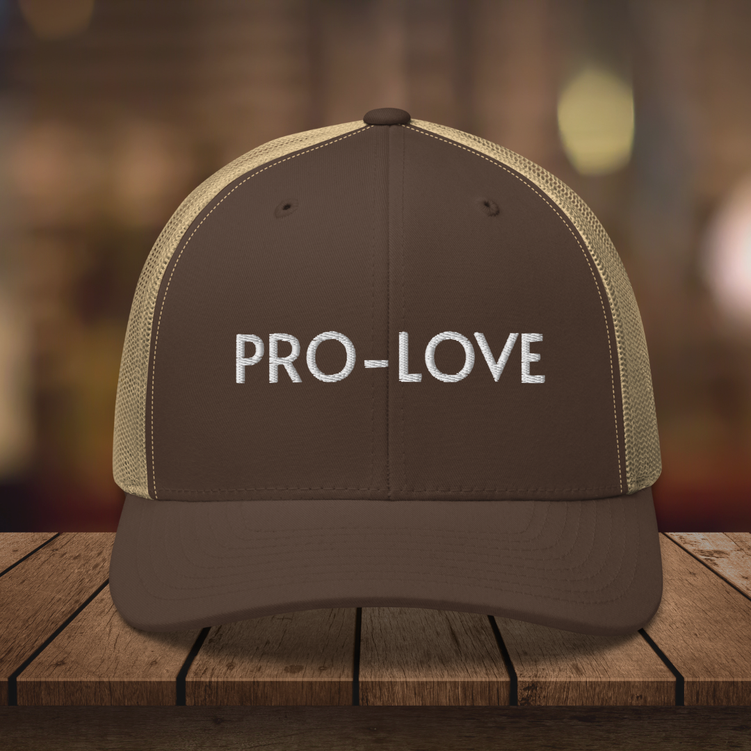 PRO-LOVE| TRUCKER HAT| FEEL THE FACTS A front view of the Pro-Love Trucker Hat, featuring the embroidered "Pro-Love" logo on the front and a stylish mesh design on the sides. BRN_KHAKI