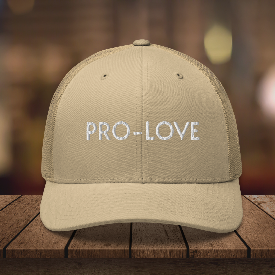 PRO-LOVE| TRUCKER HAT| FEEL THE FACTS A front view of the Pro-Love Trucker Hat, featuring the embroidered "Pro-Love" logo on the front and a stylish mesh design on the sides. KHAKI