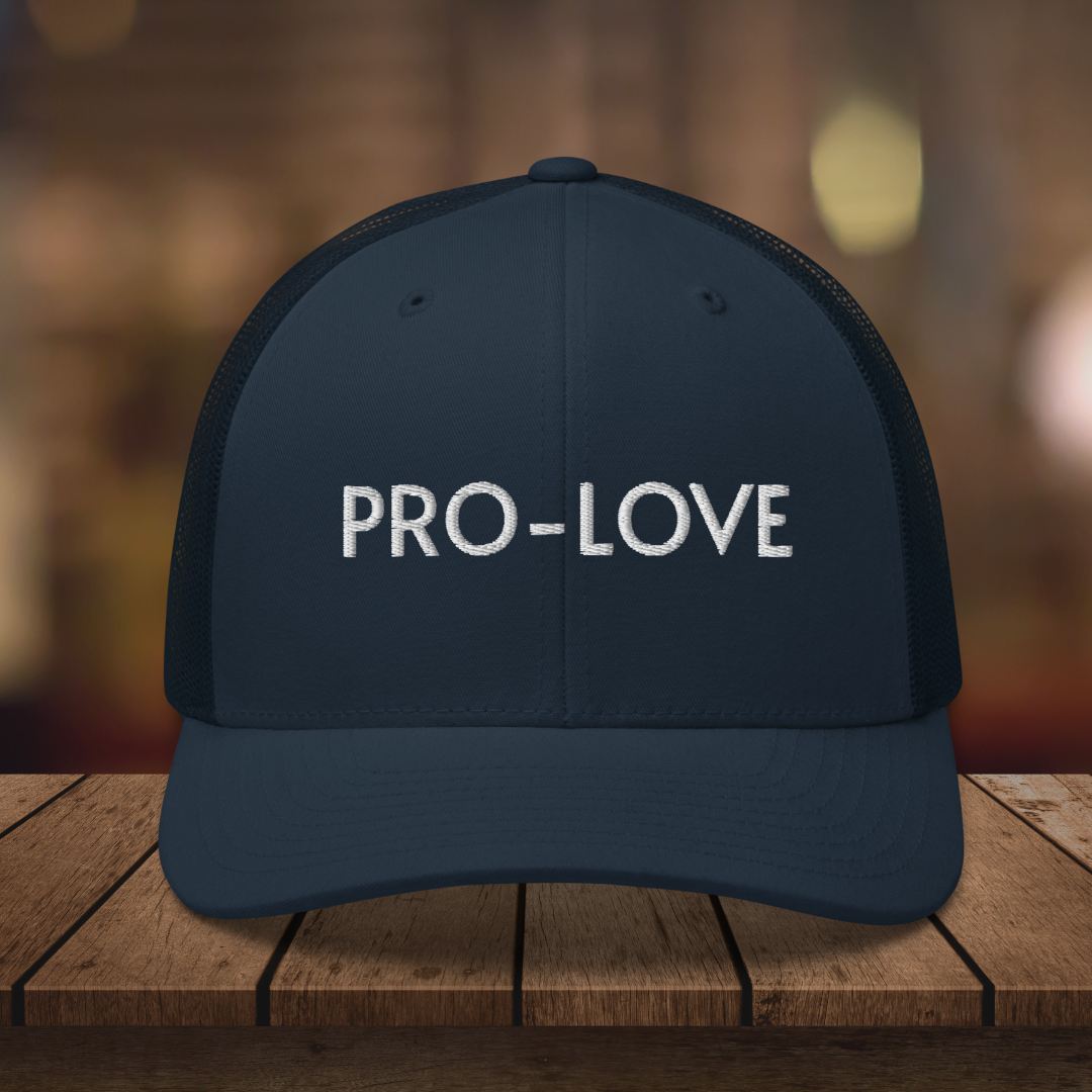 PRO-LOVE| TRUCKER HAT| FEEL THE FACTS A front view of the Pro-Love Trucker Hat, featuring the embroidered "Pro-Love" logo on the front and a stylish mesh design on the sides. NVY_BLUE