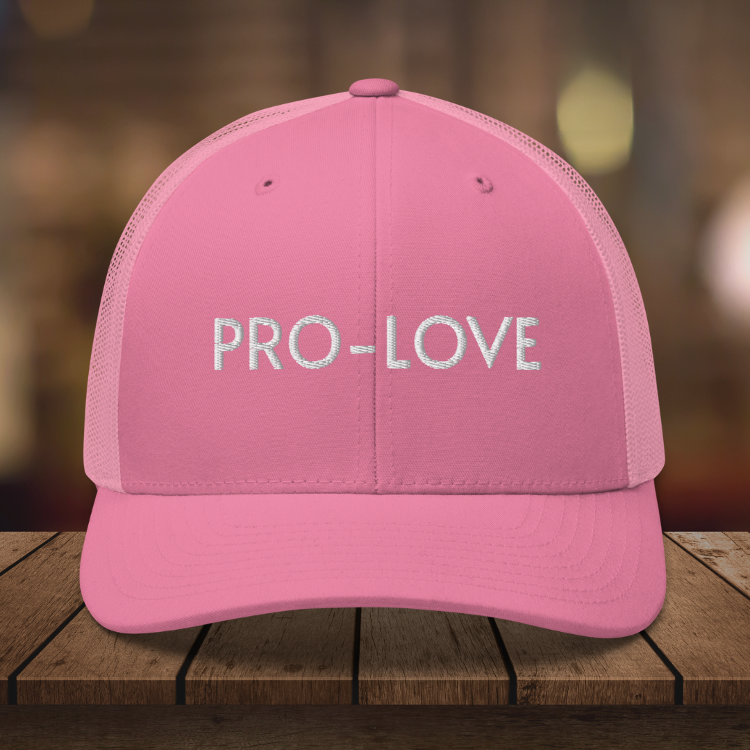 PRO-LOVE| TRUCKER HAT| FEEL THE FACTS A front view of the Pro-Love Trucker Hat, featuring the embroidered "Pro-Love" logo on the front and a stylish mesh design on the sides. PINK